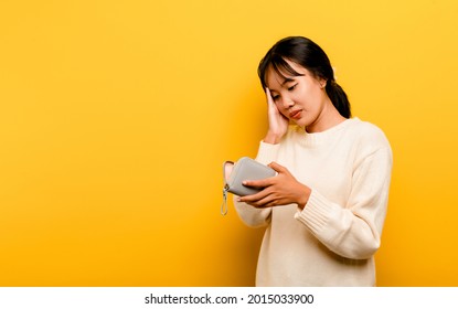 Lack Of Money Financial Problems Poor And Poor Asian Woman Carrying Empty Bag, Trouble With No Money In Debt, Expenses, Isolated On Yellow Background.