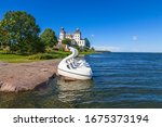 Lacko castle at lake Vanern in sweden with pedal swans at the lakeshore