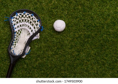 Lacrosse Stick And White  Ball On Grass Background. Team Sport Concept.