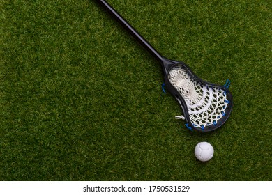 Lacrosse Stick And White  Ball On Grass Background. Lacrosse Is A Team Sport