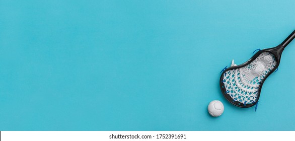 Lacrosse Stick And White  Ball On Blue Background. Lacross Is A Team Sport