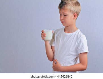 Lactose Intolerance. Dairy Intolerant Child With Stomach Pain Holding A Glass Of Milk.