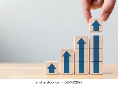 Ladder career path for business growth success process concept.Hand arranging wood block stacking as step stair with arrow up - Shutterstock ID 1454002997