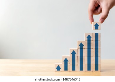 Ladder career path for business growth success process concept.Hand arranging wood block stacking as step stair with arrow up - Shutterstock ID 1487846345