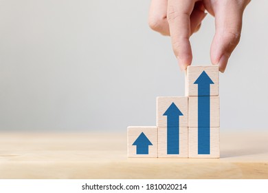 Ladder career path for business growth success process concept.Hand arranging wood block stacking as step stair with arrow up - Shutterstock ID 1810020214