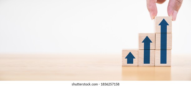 Ladder career path for business growth success process concept.Hand arranging wood block stacking as step stair with arrow up. Panoramic image - Shutterstock ID 1836257158