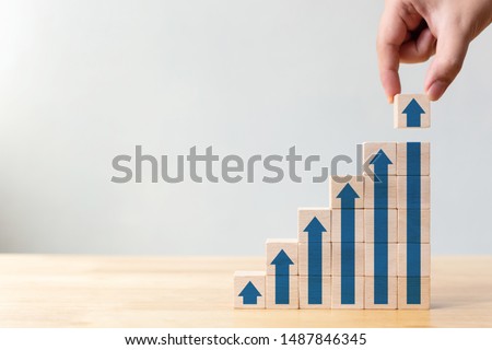 Ladder career path for business growth success process concept.Hand arranging wood block stacking as step stair with arrow up