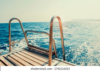 
Ladder On Deck Of Sailing Yacht Above Rippled Blue Water In Bright Sunlight.
Boat Dock With Ladder And Lake Background. River Background With Dock Ladder