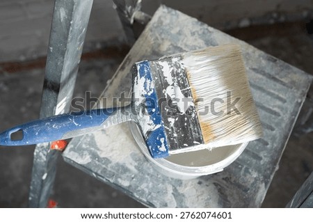Ladder with paint and brush, surface prep for painting, home finishing, renovation work, interior improvement, room decoration detail.