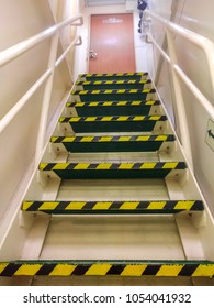 a ladder of perforated anti-slip lightweight metal steps painted in green, equipped with metal handrails of white color, leads out of the engine room , equipped with warning markers of yellow-black 