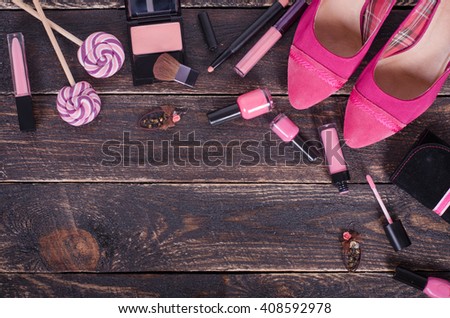 Ladies background - shoes, lipstick, nail polish, earrings, blush, lollipops.  Top view
