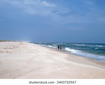 Ladies walking in the deserted beach of St. George Island State Park in the Gulf of Mexico. 