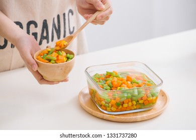 Ladle Of Steamed Freshly Harvested Young Vegetables Including Crinkle Cut Sliced Carrots, Peas And Potato For A Healthy Accompaniment To Dinner