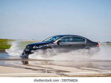 LADOUX, FRANCE - SEPTEMBER 16, 2014: Tire test is held at the proving ground. Professional test-driver performs a lateral aquaplaning test.