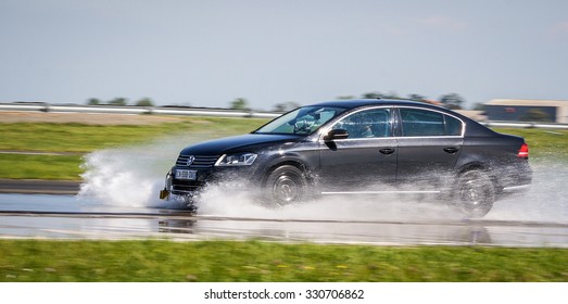 LADOUX, FRANCE - SEPTEMBER 16, 2014: Tire test is held at the proving ground. Professional test-driver performs a lateral aquaplaning test.