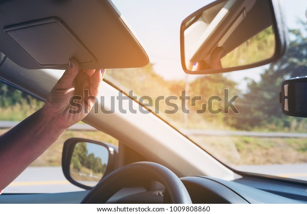 Lady adjust sun visor while driving car on\
highway road - interior car using\
concept