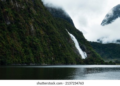 Lady Bowen Falls in Milford Sound with clouds drifting in the mountains, South Island. 