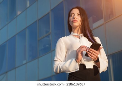 Lady Business Manager Stands Near Office And Chats With Friend. Young Woman In Businesswear Smiles And Straightens Long Dark Hair Behind Ear, Sinlight