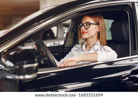 Lady in a car salon. Woman buying the car. Elegant woman in th ecar interior.