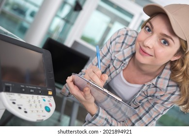 lady with clipboard servicing a photocopier