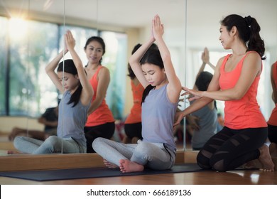 Lady coach teach an asian girl in Yoga class in fitness center, sport, health, fitness and yoga concept - Powered by Shutterstock