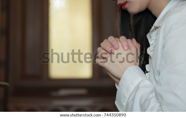 A lady confess for a sin with god, Woman confess for\
a sin with god, A woman confess for a sin with god in the church,\
Hands praying in a dark over wooden table, Age 20-30\
years,\
Confessions of Sin