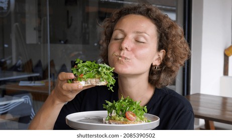 Lady Eating With Hands Big Healthy Avocado Toast With Green Salad And Cherry Tomatoes On White Plate 