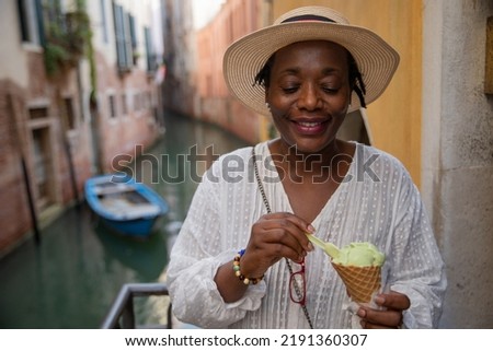 A lady eats ice cream while on vacation in Venice, Italy. Mature tourist woman during her trip