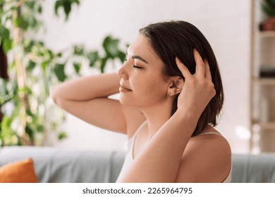 Lady enjoys giving herself a head massage. - Shutterstock ID 2265964795