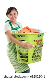 Lady In Green Apron Lifts A Basket Of Laundry And Smiles At Camera, Isolated Over White Background