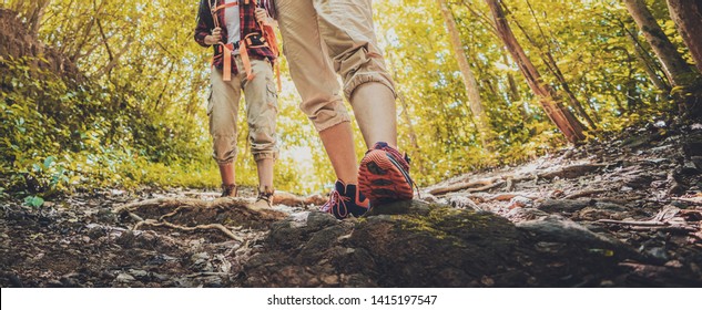 Lady Hiker Walking Through The Rocky Land. Focus On The Foot. Hiking Shoes In Action On A Mountain Desert Trail Path. Close-up Of Female Hikers Shoes. 