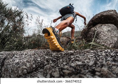 Lady hiker walking through the rocky land. Focus on the foot