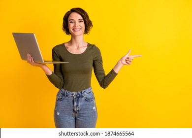 Lady hold laptop point finger empty space advertisement promo recommendation concept isolated on shine yellow color background