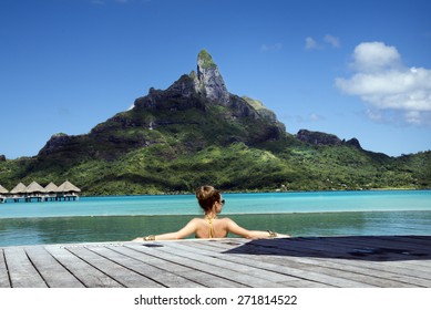 Lady In The Infinity Pool  On The Beach Of A Luxury Vacation Resort In The Lagoon And Looking On The Otemanu Mountain On The Tropical Island Of Bora Bora, Near Tahiti, French Polynesia, Pacific Ocean