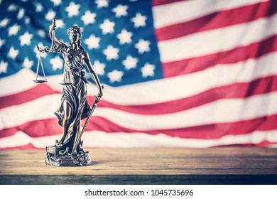 Lady Justice and American flag in the background. - Shutterstock ID 1045735696