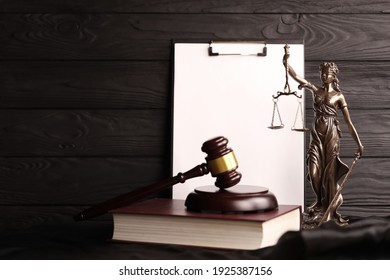 Lady justice or justitia the Roman goddess of Justice. Statue on brown book with judge gavel on blank paper background with copy space. Concept of judicial trial, courtroom process and lawyers work