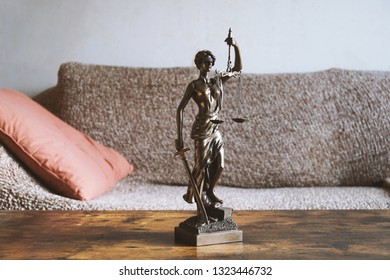 Lady Justice Or Justitia Statue On Table In Living Room - Landlord And Tenant Law Or Right Of Residence Concept