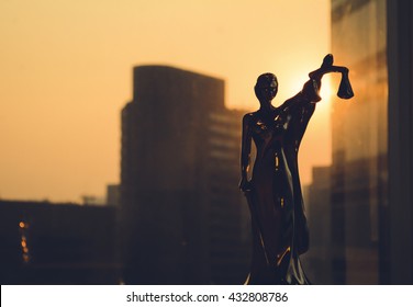 Lady Justice, Law concept. Silhouette of Themis with building background. Statuette of justice. Statuette of the goddess of justice