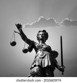 Lady justice at the Roemer in Frankfurt am Main symbolizes Justice with sword and scales in sunset.