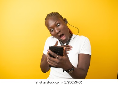 A Lady Looking Into Her Phone And Looking Suprised