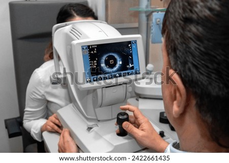 Lady looking at refractometer eye testing machine in ophthalmology, tonometer, refractometer. Eye examination for glasses or lenses prescription. Ophthalmologist Ophthalmic Exam Concept. optometrist