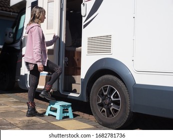 A Lady Motorhome Owner Enters Her Van Through The Side Door By Stepping Up Onto A Small Step.Sunny Day.Image