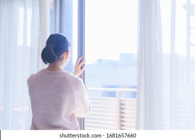 Lady Is Opening Curtain And Window