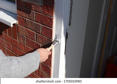 Lady Painting White Wood Frame On Doorway 