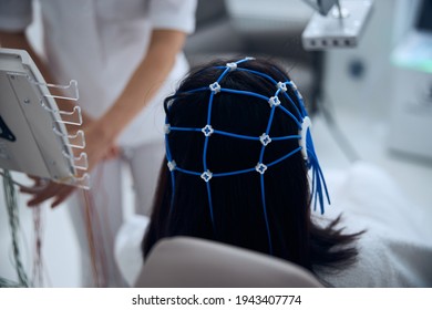 Lady patient in a silicone cap undergoing the EEG procedure