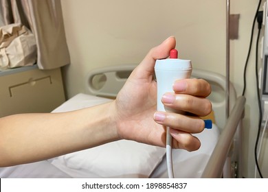 Lady patient using nurse call button for emergenvy bell in hospita wardl. Nusre call button. Hand in saline solution injection. 
