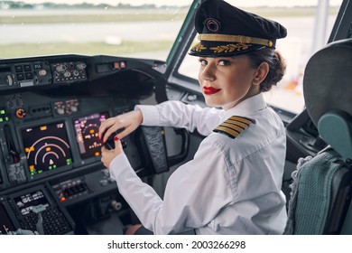 Lady pilot posing for the camera in the cockpit