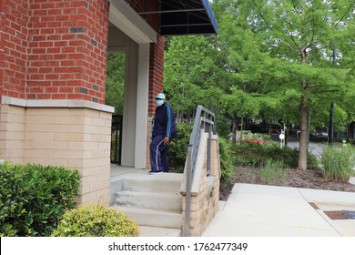 Lady With A Protective Mask Entering A Brick Building From A Cement Staircase With A Green Background