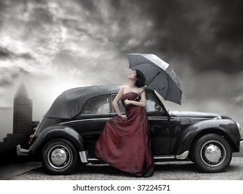 Lady In Purple Dress And Holding Umbrella Next To Vintage Luxury Car