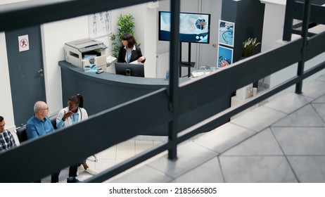 Lady receptionist working at hospital reception desk to help patients with medical appointment. Healthcare employee in waiting room lobby, checkup visit report with medication.